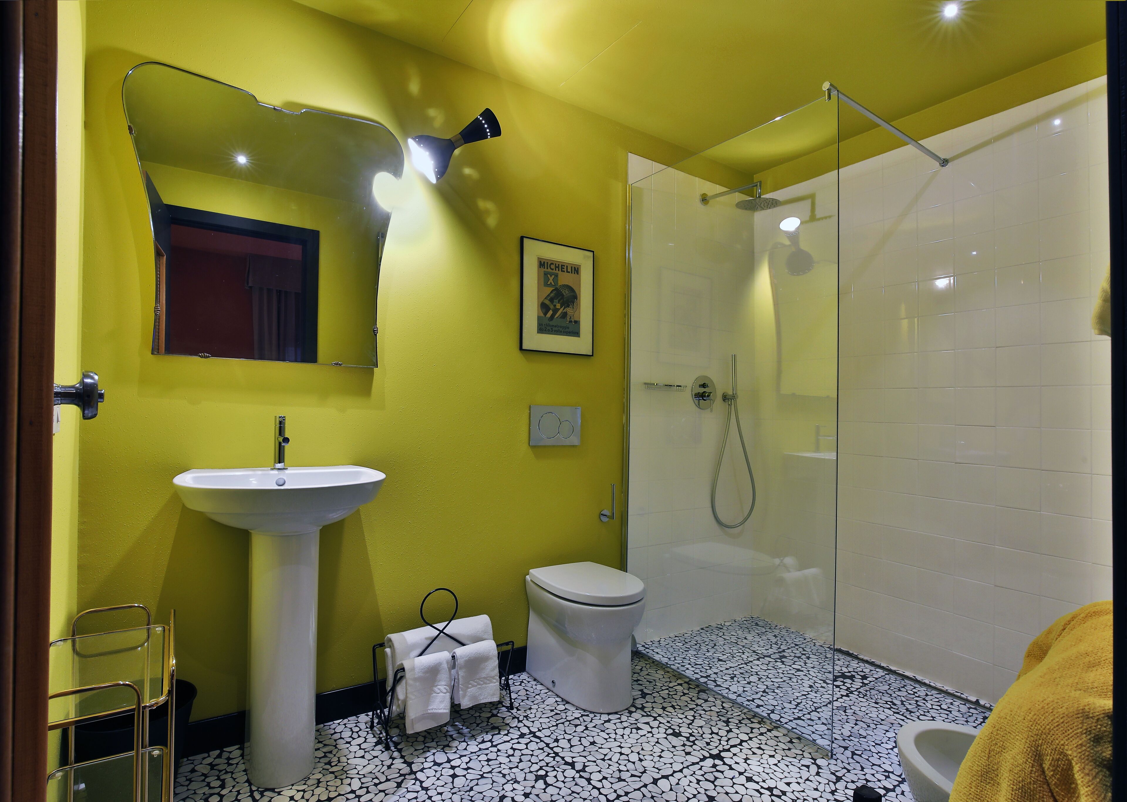 A bathroom with a white sink, toilet, and glass-enclosed shower.