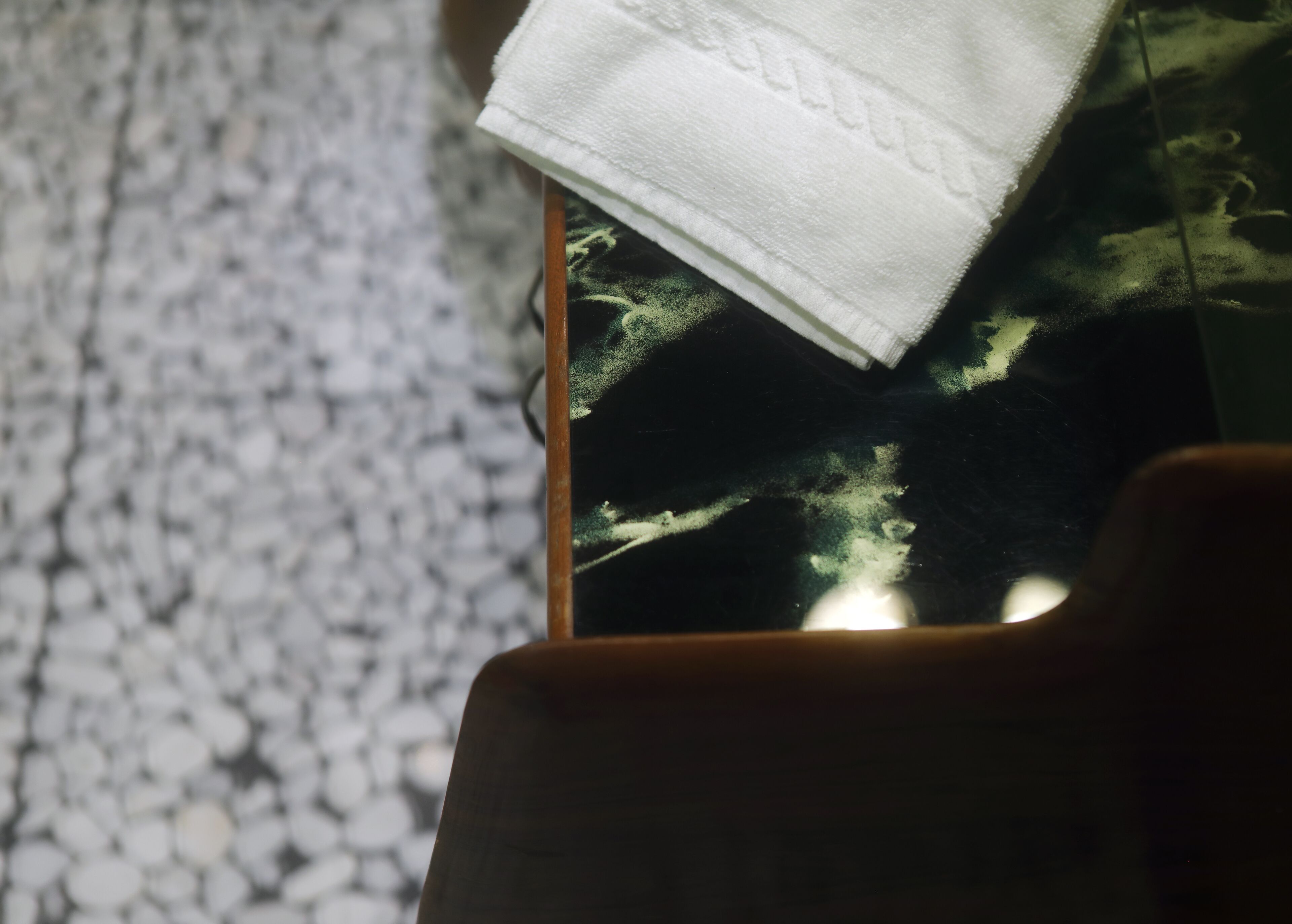 A smartphone with a white cloth on top, placed on a textured surface.