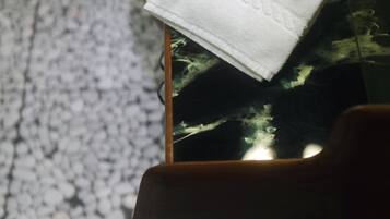 A smartphone with a white cloth on top, placed on a textured surface.