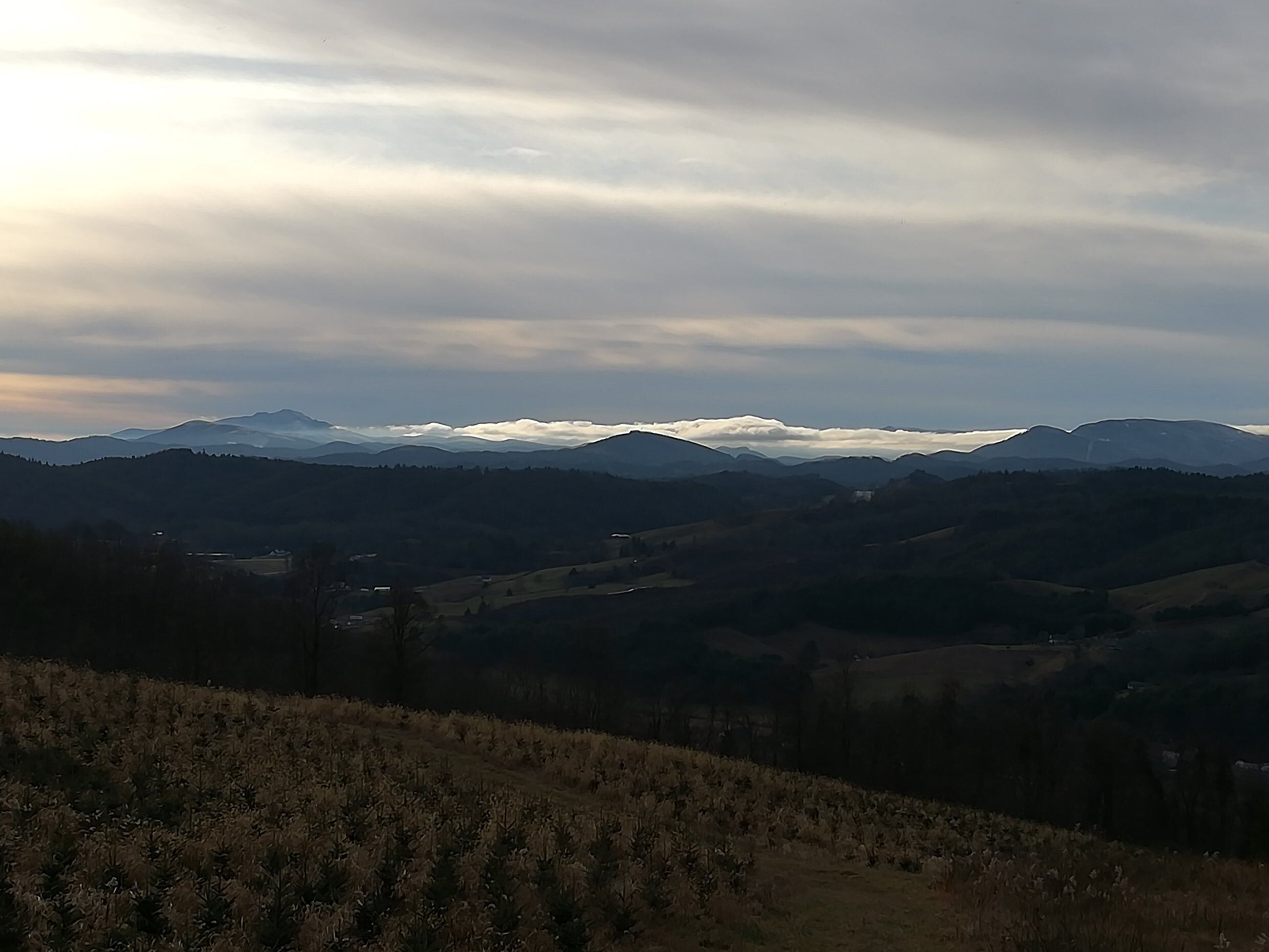 A panoramic view of a mountainous landscape with rolling hills and a valley.