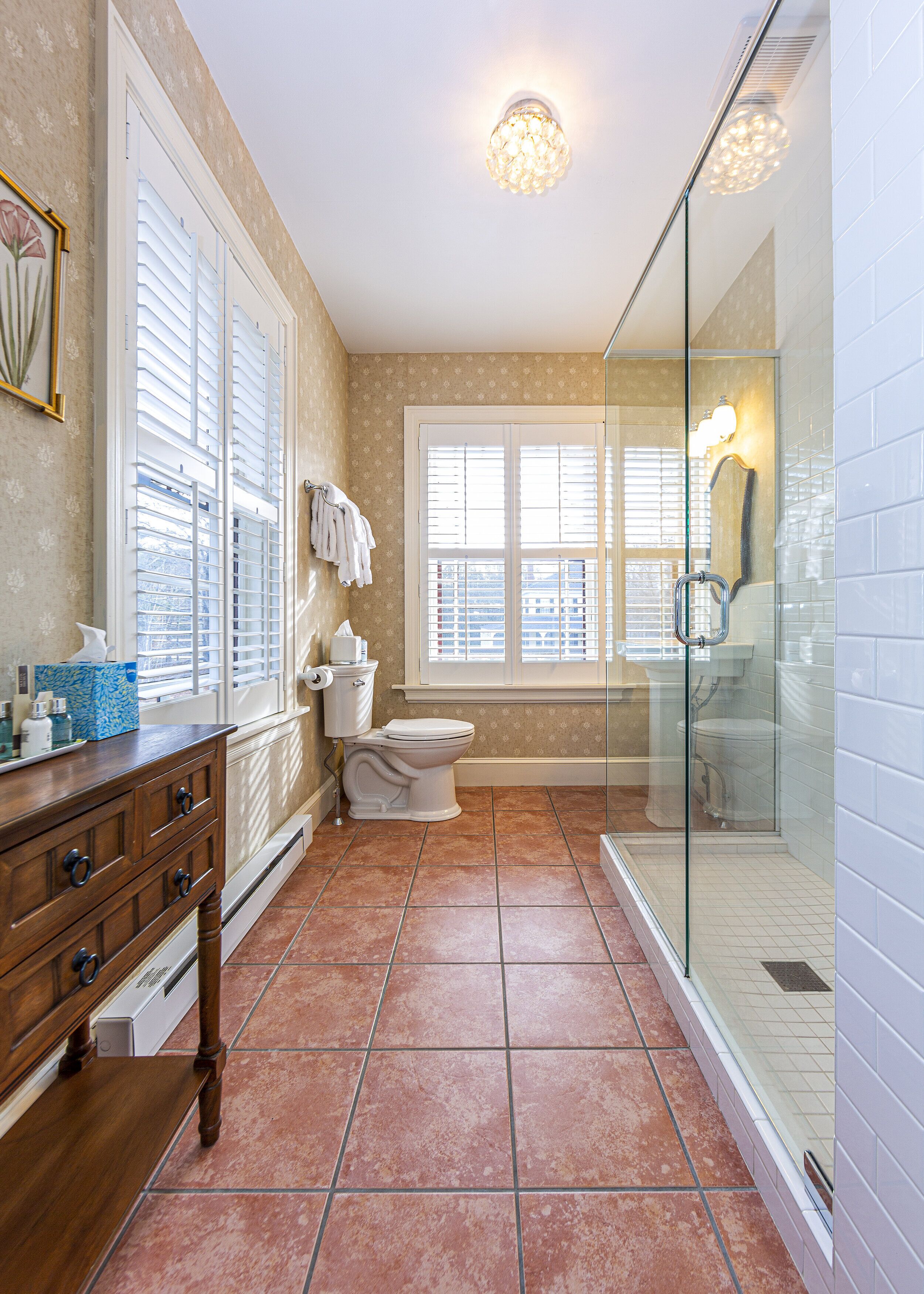 A bathroom with a toilet, sink, and shower area.