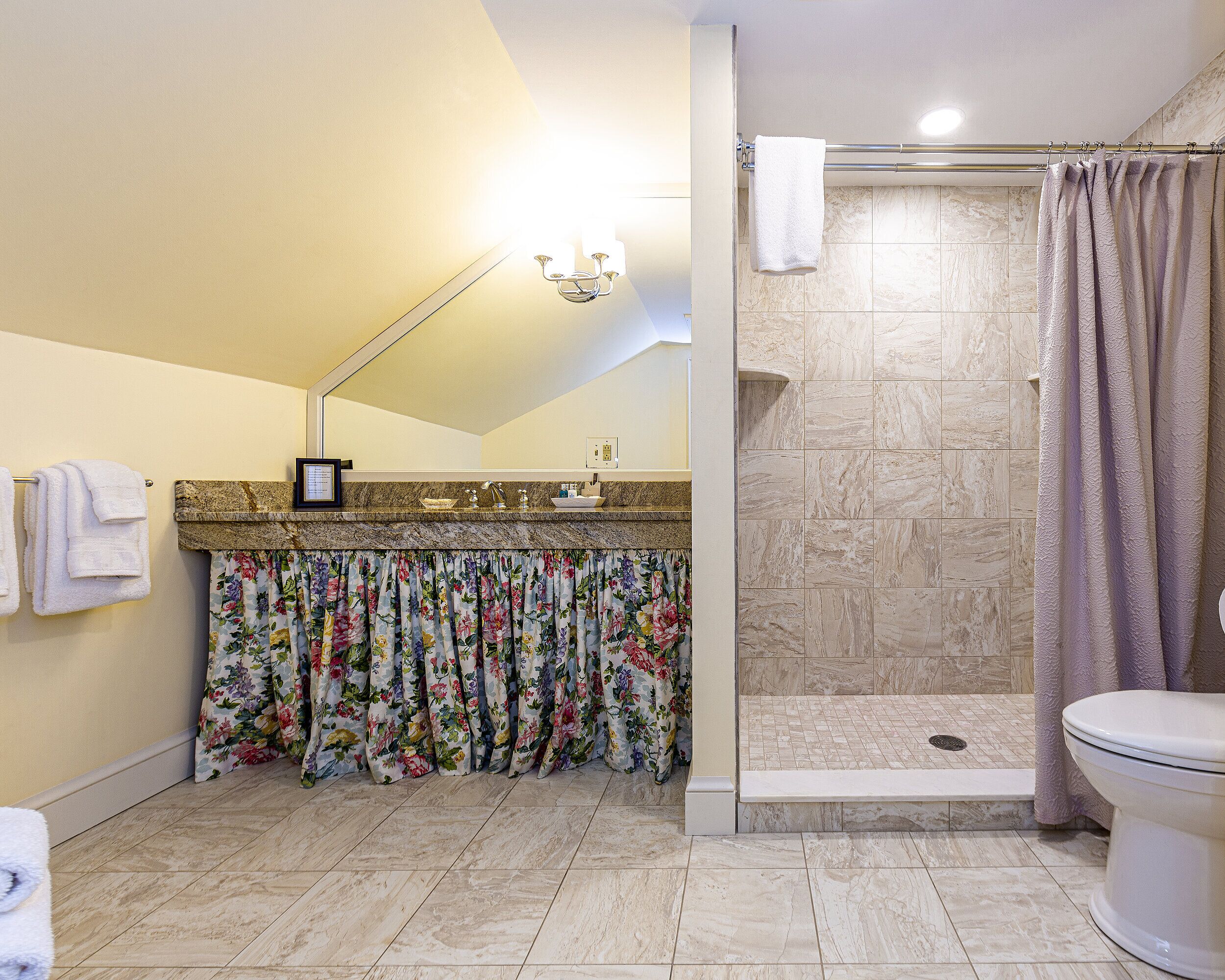 A bathroom with a shower, toilet, and sink.