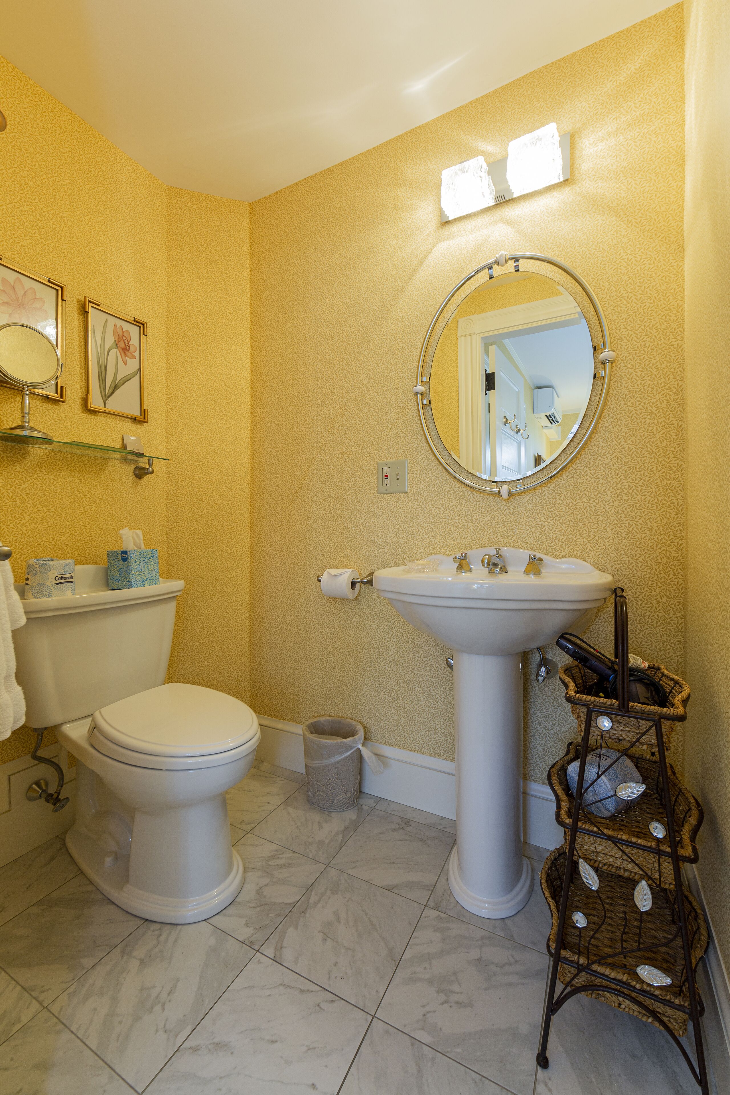 A bathroom with a toilet, sink, and mirror.