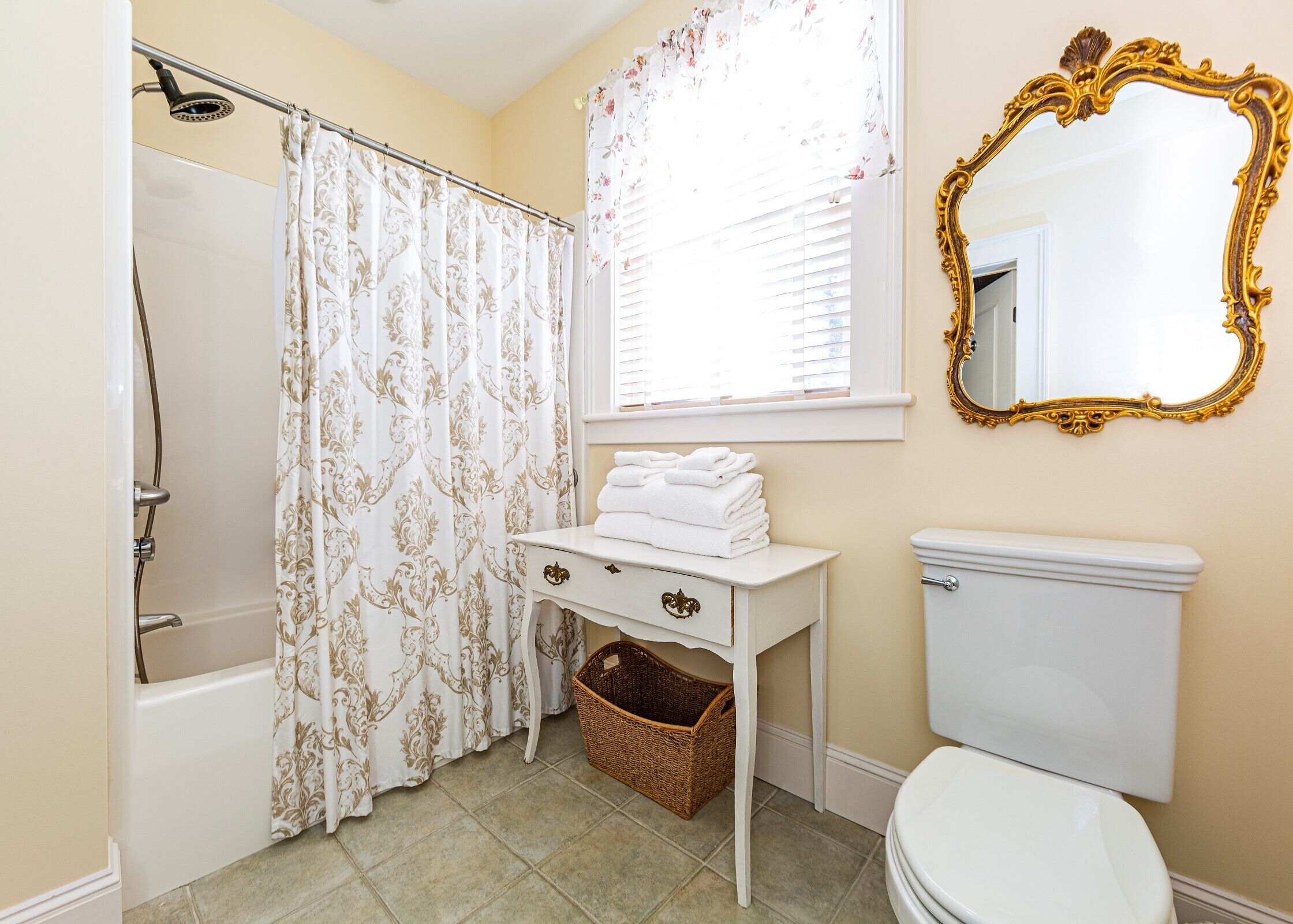 A bathroom with a shower, toilet, and a vanity with a mirror.