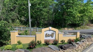 Un letrero con el nombre 'Briardiff' rodeado de una zona ajardinada con rocas y plantas.