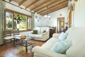 Relax in this stylish living area with a high ceiling, sofa, armchair, and dining table.