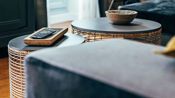 A cozy room with a round table, a lamp, and a view of a balcony.