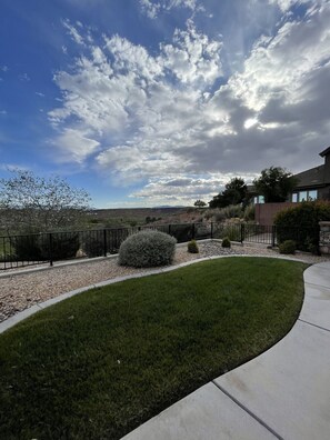 A residential area with a well-maintained lawn, a stone pathway, and a house with a modern design.