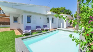 A modern house with a swimming pool, two lounge chairs, and a well-maintained lawn. - Villa Calma – Peaceful Comfort Just Minutes from the Beach | Can Picafort (Can Picafort)