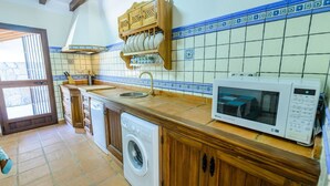 A kitchen with a washing machine, a microwave, and a sink. - Los Linarejos Ronda by Ruralidays (Málaga)