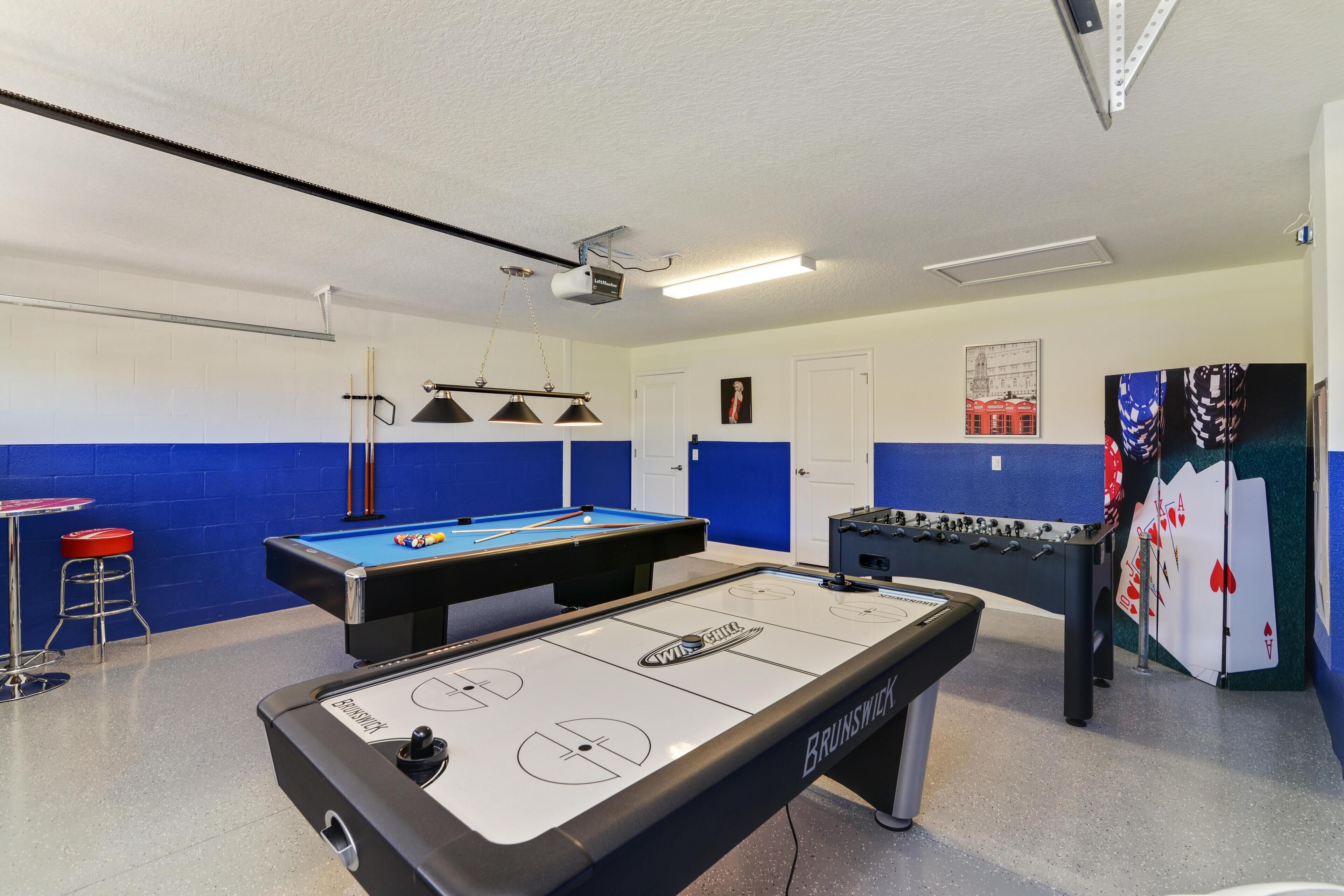 Une pièce équipée d’une table de billard, d’un baby-foot et d’une table de jeu de palet.
