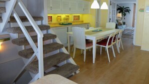 A staircase with carpeted steps leading to a dining area with a table and chairs. - 4 br townhouse ocean front, at 47th St, has outdoor pool! Lovely, with multiple oceanfront decks. (Ocean City)