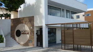 Un edificio moderno con un ampio logo circolare, una scala e un ingresso sorvegliato da cancello.