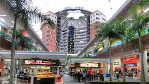 A hotel with a central atrium, a pool, and various shops. - Rincon de Granada (Cali)