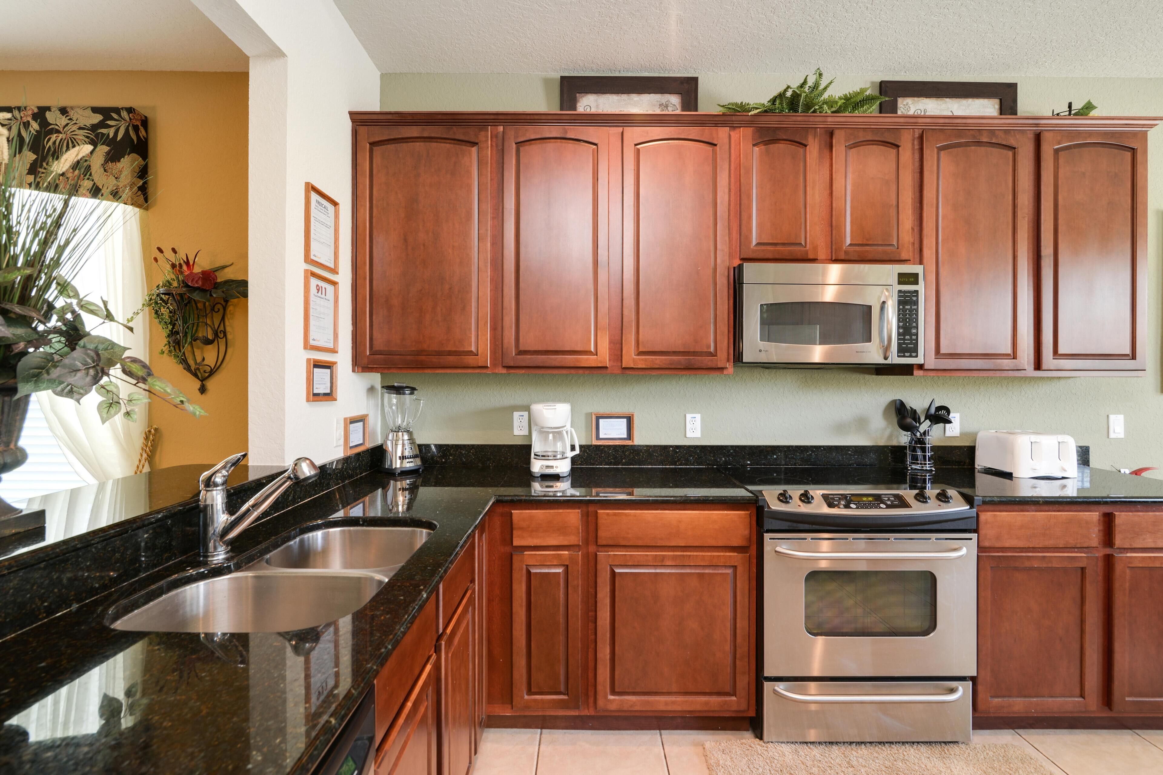 A kitchen with wooden cabinets, stainless steel appliances, and a granite countertop.