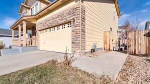 A two-story house with a garage, a covered porch, and a stone facade. - Beautiful place for staying (Aurora)
