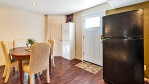 A compact kitchen with a dining table, chairs, a refrigerator, and a door with a window. - Beautiful place for staying (Aurora)