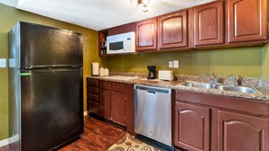 A kitchen with wooden cabinets, a black refrigerator, a microwave, a coffee maker, and a dishwasher. - Beautiful place for staying (Aurora)
