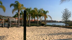 A sandy beach with palm trees and a volleyball net. - Fantasy Villa by VillaDirect (Kissimmee)