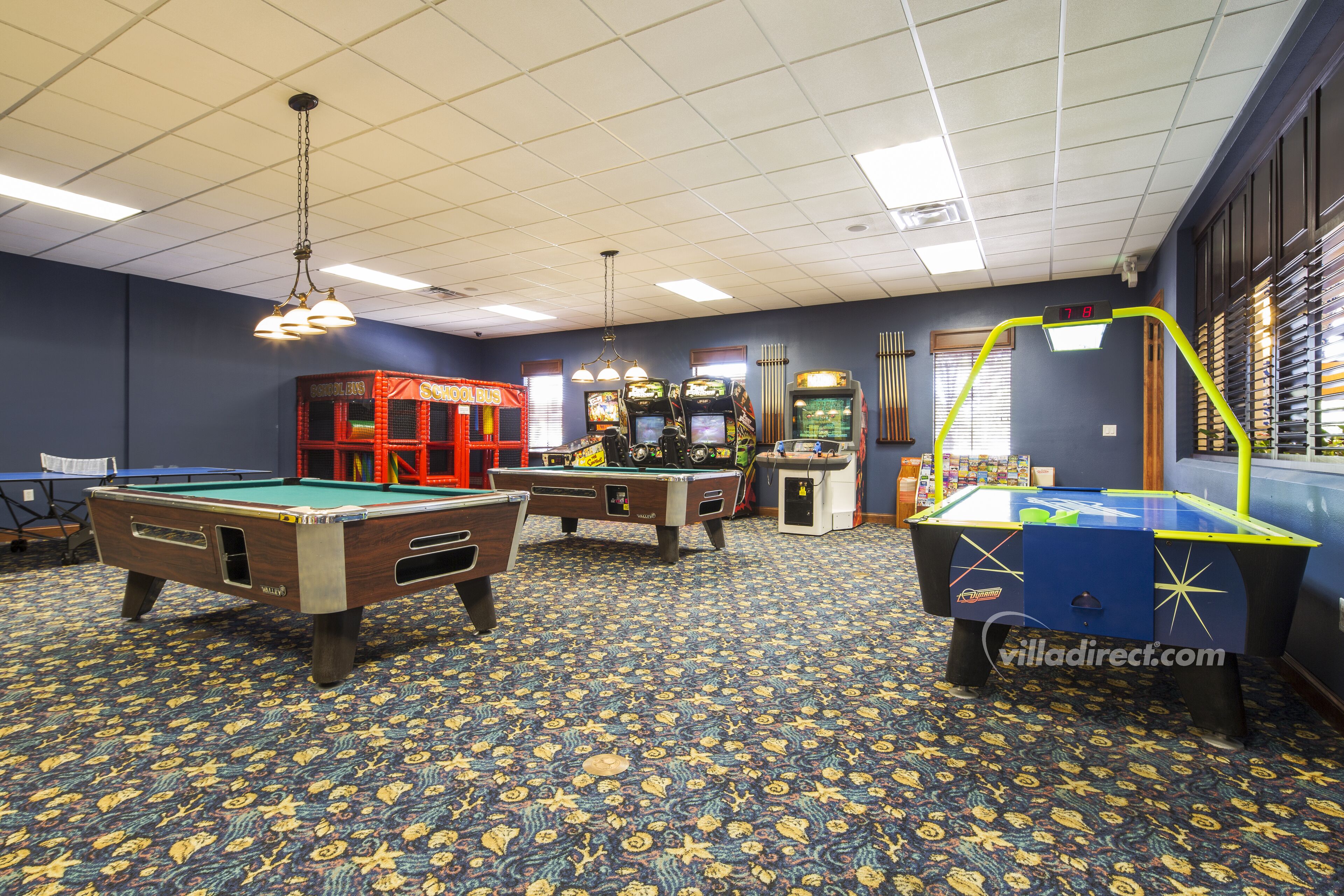 Een poolzaal met meerdere pooltafels, een biljarttafel en speelautomaten.