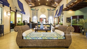 A lobby with a large woven sofa, a reception desk, and a fish tank. - Paradise Getaway by VillaDirect (Kissimmee)