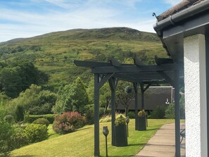 A covered outdoor area with a view of a green hillside. - 3 bedroom accommodation in Banavie, near Fort William (Banavie, near Fort William)