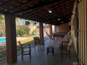 A covered patio area with outdoor furniture, a hammock, and a pool in the background. - Beachfront Paradise – House with Pool and Barbecue, 400m from the Beach (Cibratel II)