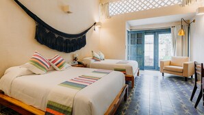 A hotel room with two beds, a hammock, a chair, and a view of the outside. - Waye Valladolid Centro – Sustainable, Authentic Experiences & Pet Friendly Boutique Hotel (Valladolid)