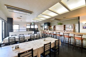 A restaurant with multiple dining tables, chairs, and a bar area. - Hotel S-Pal (Hakodate)
