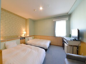 A hotel room with two single beds, a desk with a computer, a chair, and a window with curtains. - Hotel S-Pal (Hakodate)