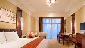 Una habitación de hotel con una cama grande, un escritorio, una silla y un televisor.