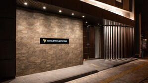 La façade extérieure de l’hôtel Vista Matsuyama, avec son revêtement en pierre et son panneau indicateur.