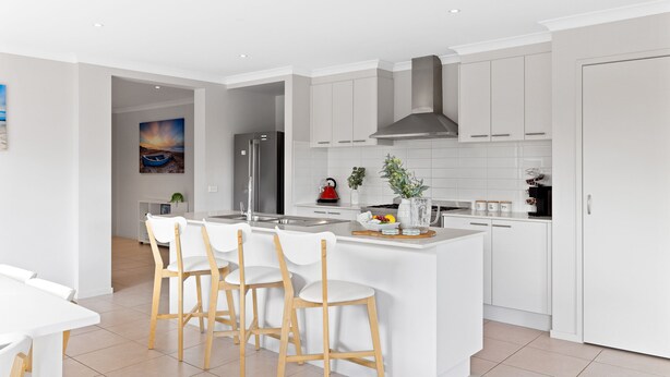 A modern kitchen with white cabinetry, a central island with bar stools, a stainless steel refrigerator, and a large window. - Island Luxe Retreat Cowes. Modern Holiday House, Powerful outdoor spa/jaquzzi. (Cowes)