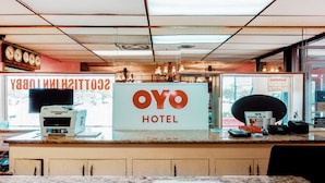 A reception area with a sign reading "OYO HOTEL" and a counter with a printer. - OYO Hotel Alice TX Hwy 281 West (Alice)