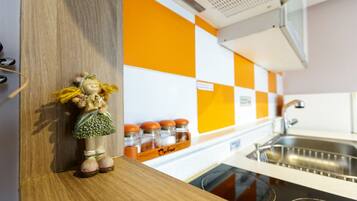 A kitchen with a wooden countertop, a sink, and a spice rack with jars.