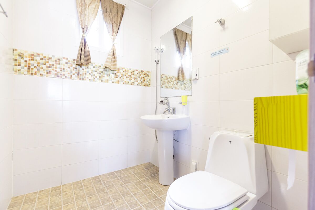A bathroom with a white sink, a toilet, and a mirror.