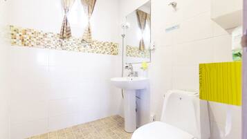 A bathroom with a white sink, a toilet, and a mirror.