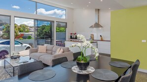 Una sala de estar moderna con un sofá, una mesa de centro y una planta de orquídea.