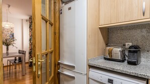 Cozinha compacta com geladeira, torradeira e lava-louças.