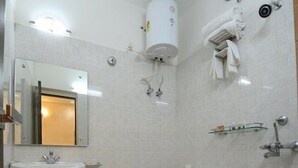 A bathroom with a sink, toilet, and shower. - Hotel Rigal inn (Agra)
