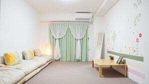 Una camera da letto con un letto, un comodino, uno specchio e una parete decorata con motivi floreali.