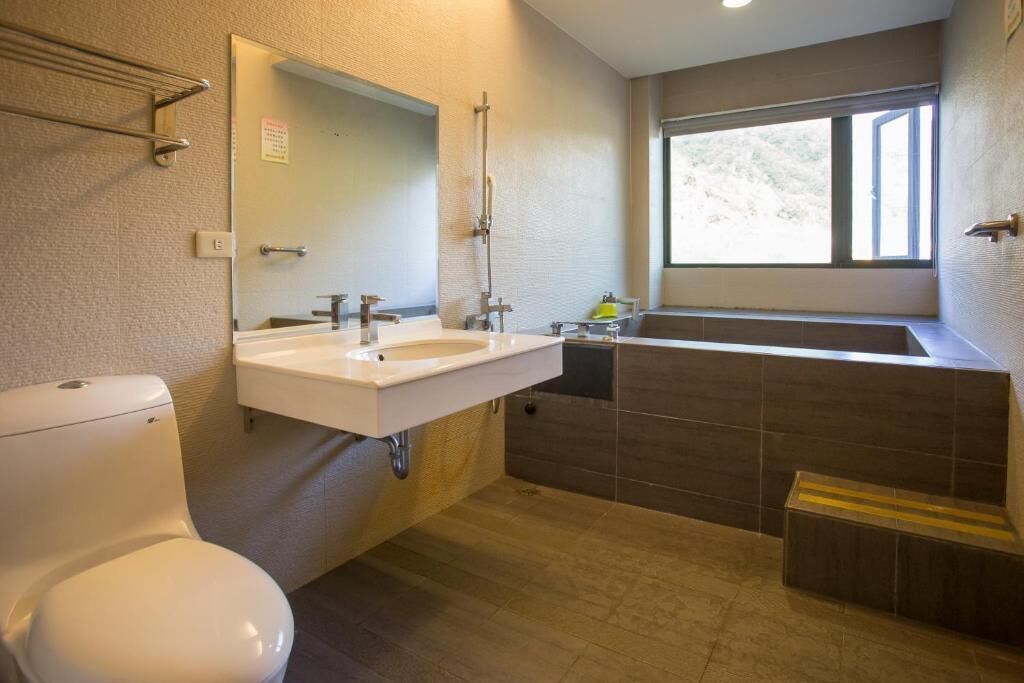 A bathroom with a toilet, sink, and bathtub.