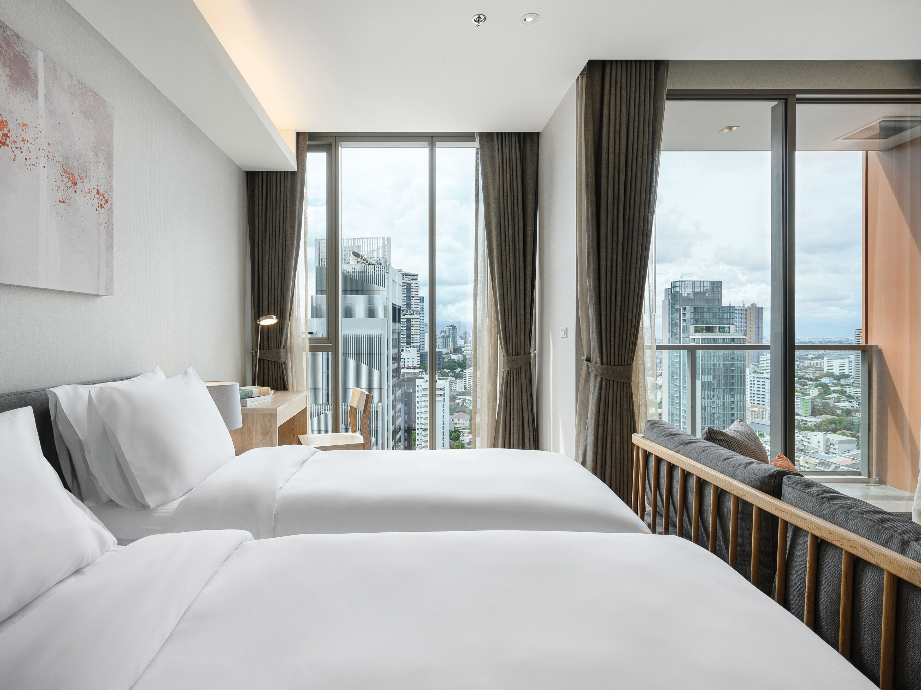 Une chambre d’hôtel avec deux lits, un bureau et une vue sur le paysage urbain.