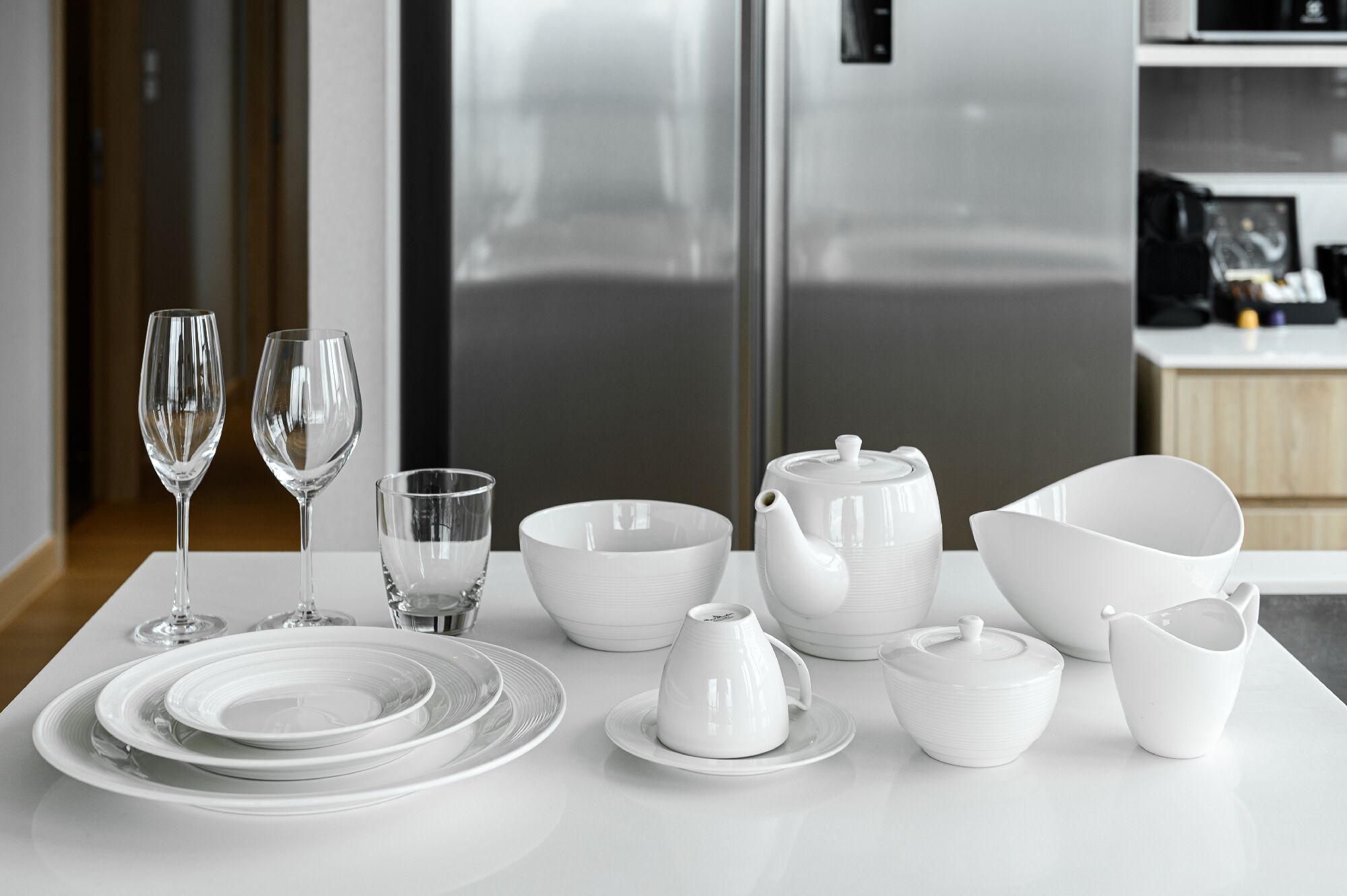 A modern kitchen with white appliances and dining ware.