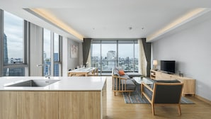 Een modern appartement met keuken, eetgedeelte en woonkamer, met grote ramen en uitzicht op de stad.