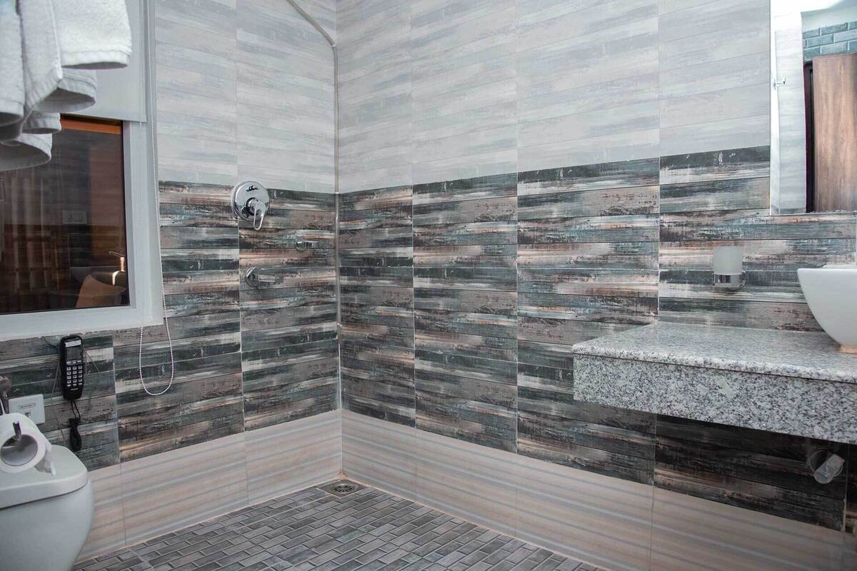A modern bathroom with a shower area, a toilet, and a sink.