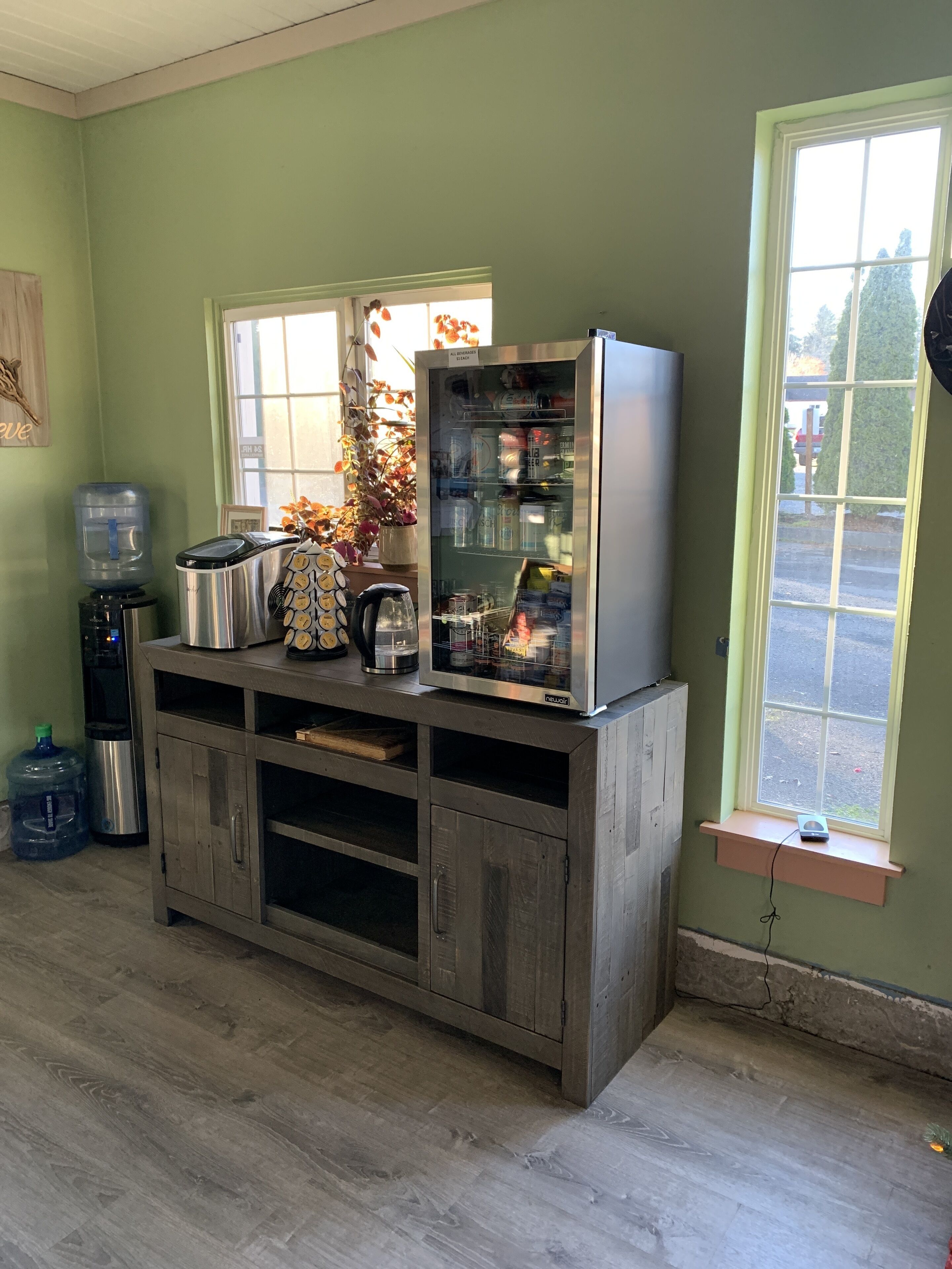 Eine Küche mit integriertem Kühlschrank, Wasserspender und Kaffeemaschine auf einem Holzkorpus.
