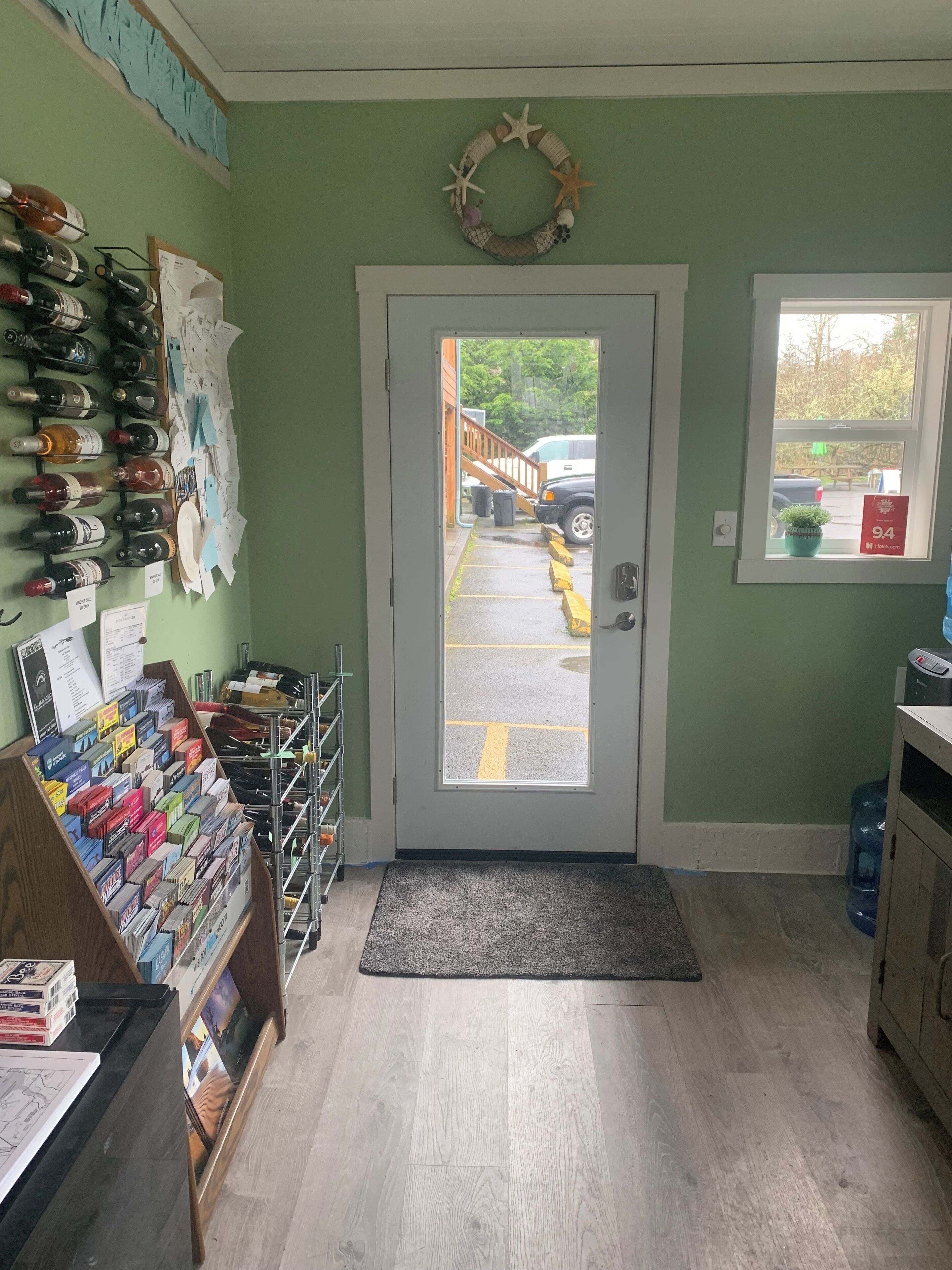 A room with a door leading outside, a shoe display, and a window with a view of the outside.