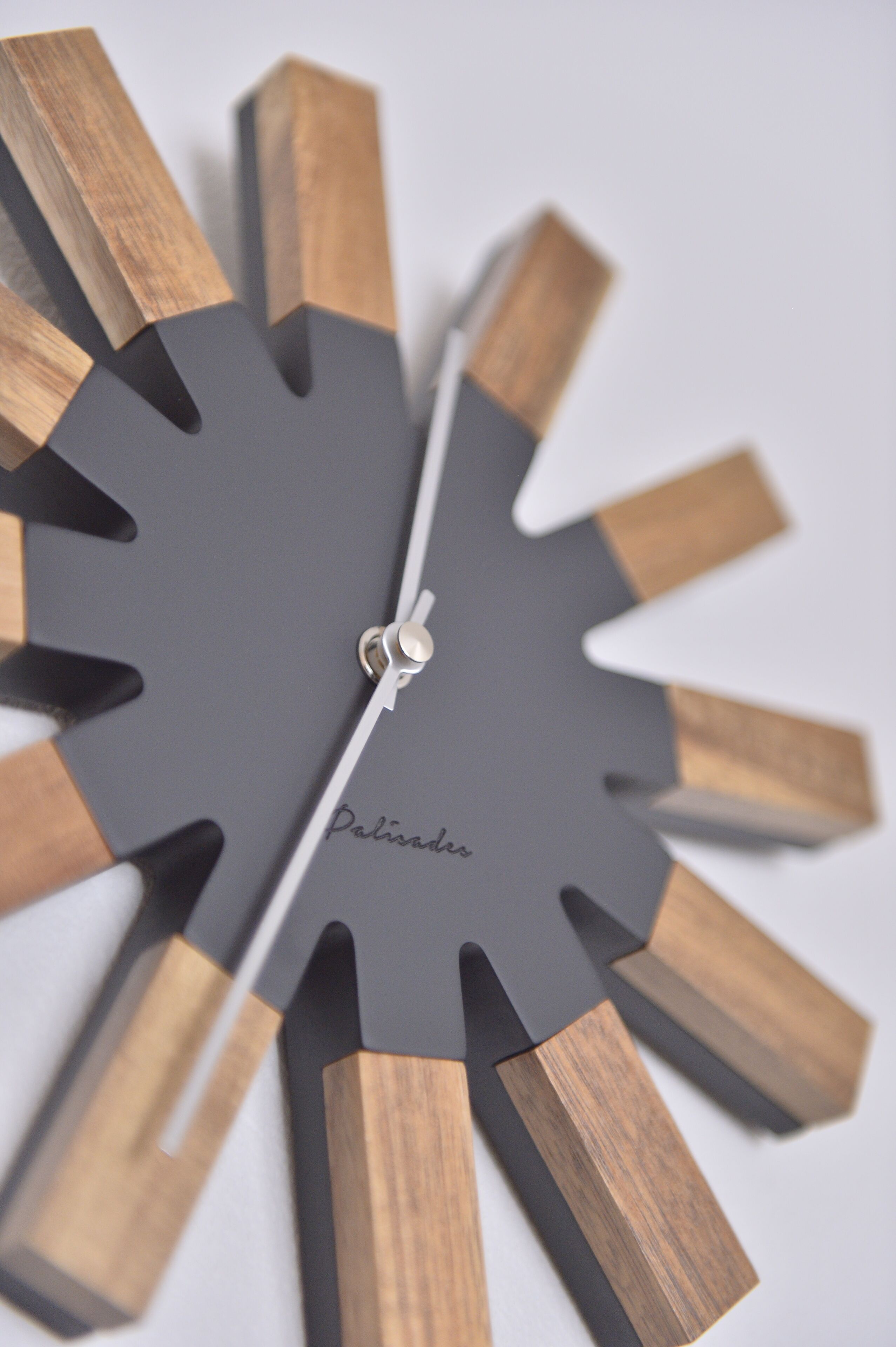 A clock with a unique design featuring wooden and black elements.