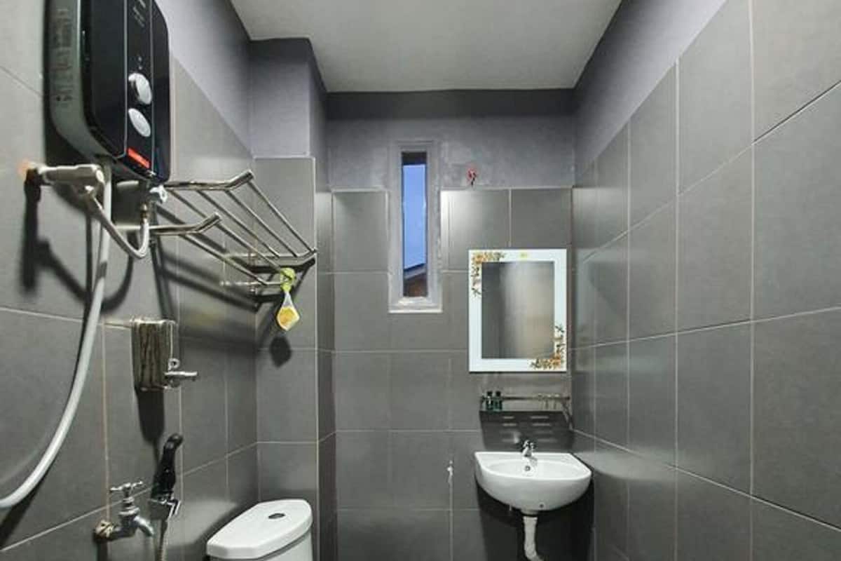 Une petite salle de bain comprenant des toilettes, un lavabo et une douche.